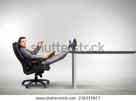 Young businessman sitting in chair with book in hands