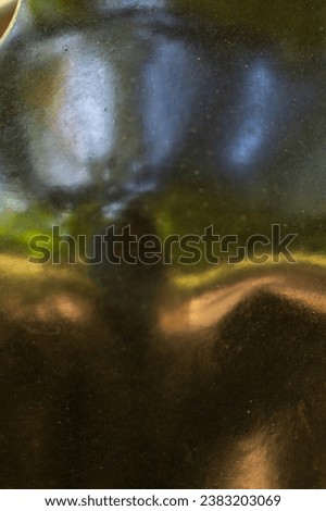 abstract close up of reflection on smooth black stone carving green gold and blue colors of reflecting trees sky and grass artsy backdrop background  wallpaper with room for type vertical image 