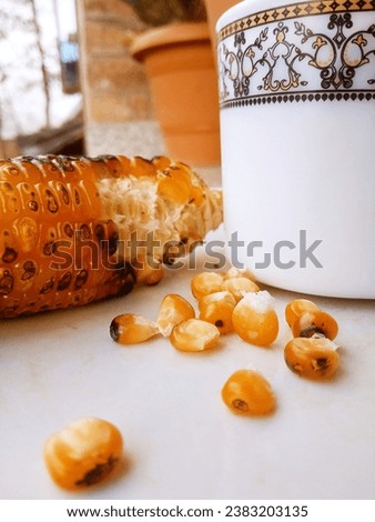 These pictures are presenting a view of roasted corn with a cup of tea in the morning .