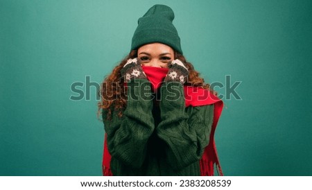 Freezing cold woman bundles up against the cold, huddles in warm scarf, studio Royalty-Free Stock Photo #2383208539