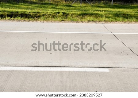 Part of a white dividing strip on a highway made of concrete