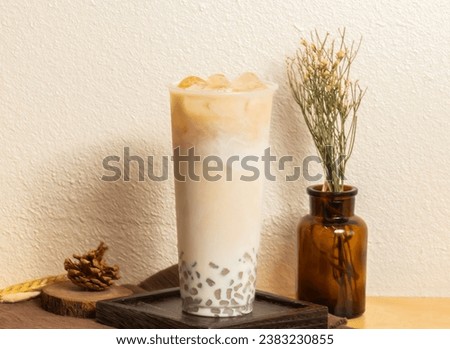 Iced Winter Melon Fresh Milk Taro tea served in disposable glass isolated on wooden board side view of taiwanese ice drink Royalty-Free Stock Photo #2383230855