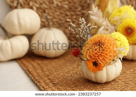 Small pumpkin with autumn bouquet on table, selective focus