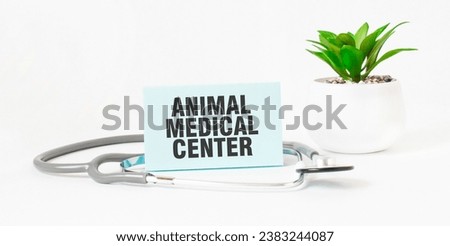 ANIMAL MEDICAL CENTER word on notebook, stethoscope and green plant