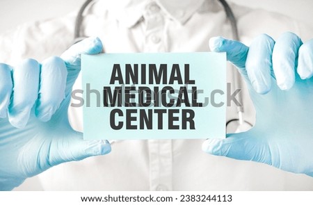 Doctor holding card in hands and pointing the word ANIMAL MEDICAL CENTER