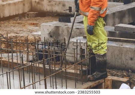 Concrete cast-in-place work. Builder level wet concrete. Concrete works on buildiiing construction site Royalty-Free Stock Photo #2383255503