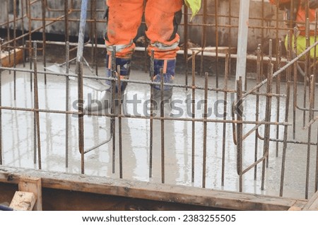 Concrete cast-in-place work. Builder level wet concrete. Concrete works on buildiiing construction site Royalty-Free Stock Photo #2383255505