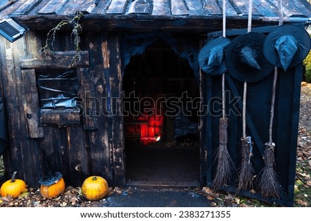A haunted witch's house decorated with pumpkins, hats and brooms Royalty-Free Stock Photo #2383271355