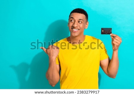 Photo of confident optimistic promo guy indicate finger empty space shopping store advert debit card atm isolated on cyan color background