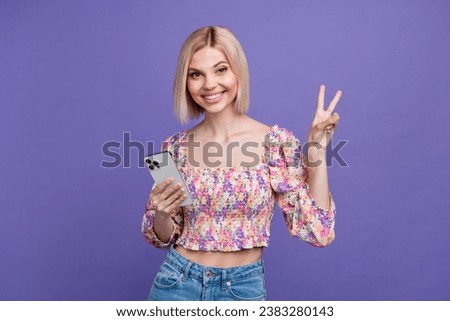 Photo of adorable cute lady wear flower print crop top communicating modern gadget showing v-sign isolated violet color background