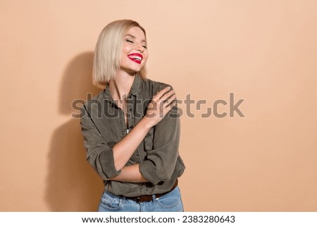 Photo of dreamy adorable woman dressed khaki shirt embracing herself closed eyes empty space isolated beige color background