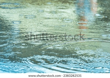 Rain drops on the surface of the water forming ripples Royalty-Free Stock Photo #2383282531