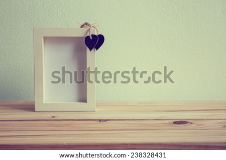 White photo frame and teddy bear on wooden table over grunge background, Valentine concept