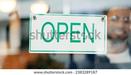 Storefront, small business or open sign on window in coffee shop or restaurant for service or advertising. Man, portrait or entrepreneur holding board, poster or welcome for message in cafe or diner