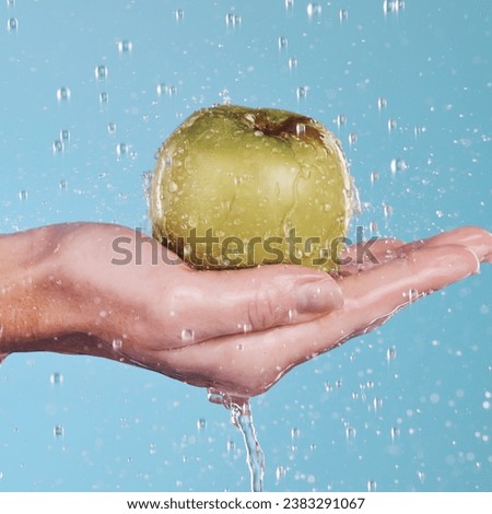 Health, water and a hand with an apple on a blue background for nutrition, cleaning or wellness. Diet, food and closeup of a person with a fruit in palm for a detox isolated on a studio backdrop