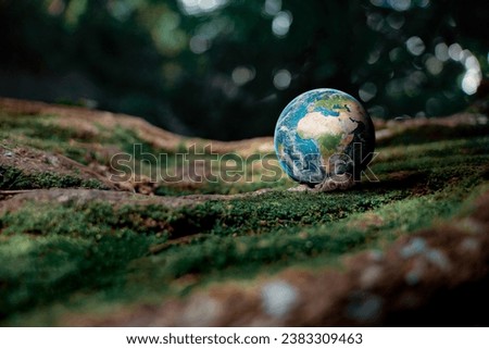 A picture of a globe standing in the middle of nature. ,Campaign about loving the environment environmental friendliness