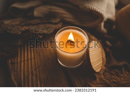 Burning candle in home interior, autumn aesthetics.