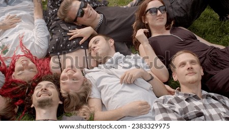 Enjoying Nature: People lie on the grass to feel more connected to nature. Simple way to appreciate the outdoors, watch the clouds, listen to birdsong, and escape the hustle and bustle of urban life. Royalty-Free Stock Photo #2383329975