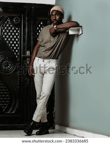 full picture of a black male standing close to a wall