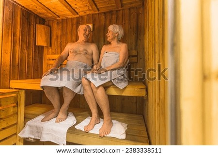 full shot of a old lovely couple with grey towels having a great time in the sauna, old people concept. High quality photo