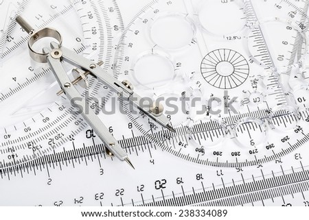 pair of compasses on transparent rulers and protractors