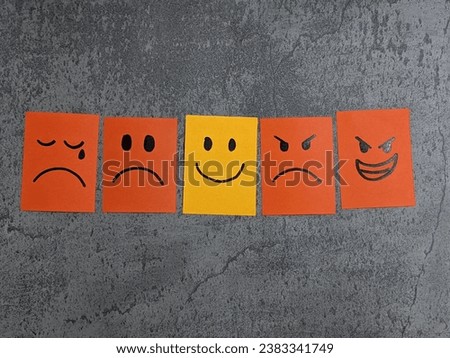 Positive mind attitude. Many office notes with handwriting emoticon face. Multiple face and one that stand out with a smile