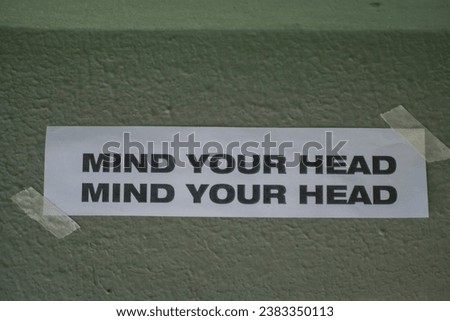 Mind Your Head sign Above Doorway or foot step. Low up ceiling caution, head lowering instruction, drop hazard Royalty-Free Stock Photo #2383350113