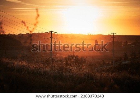 Sunset hills with telephone or power line poles                      