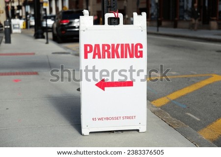 parking sign stands against a backdrop of urban life, a symbol of order and regulation in the bustling cityscape