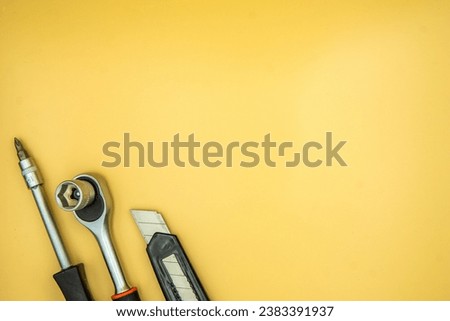 screwdriver torque and knife isolated on cream background