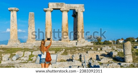Temple of Apollo, ruins of ancient temple in Corinth- woman tourist taking picture with smarpthone- travel in Greece, Europa