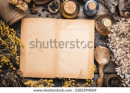 Recipe book. Magic book. Herbal medicine concept background. Dry natural ingredients and remedy bottle on the wooden table background with copy space. Top view. Witchcraft. Royalty-Free Stock Photo #2383394069