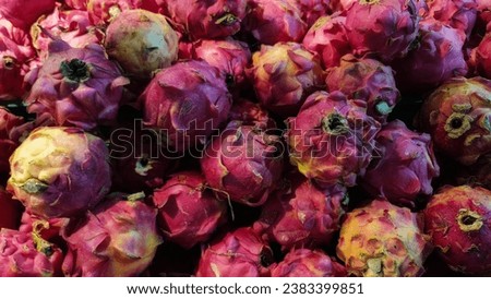 A GROUP OF DRAGON FRUIT STACK ON THE TABLE