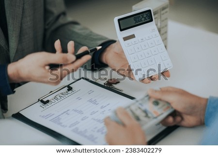 Close-up photo of a real estate agent offering a contract to purchase or rent a residence. Businessman holds small house model with property insurance at table in home sales office