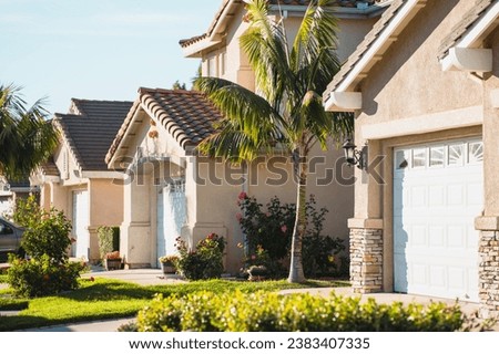 Beautiful houses with nicely landscaped front yard. Architecture, ornamental plants and flowers, palm trees Royalty-Free Stock Photo #2383407335