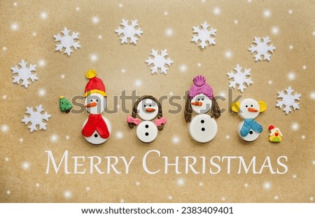 Handmade Christmas card.  Snowmen made of plastic caps and plasticine.  Cute family snowman on a New Year's background.  Merry Christmas greetings.  Flat lay, top view.  Holiday concept.