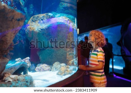 Family in aquarium. Kids watch tropical fish, marine life. Child looking at sea animals in large oceanarium. Ocean life museum. School or vacation day trip to aqua park. Royalty-Free Stock Photo #2383411909