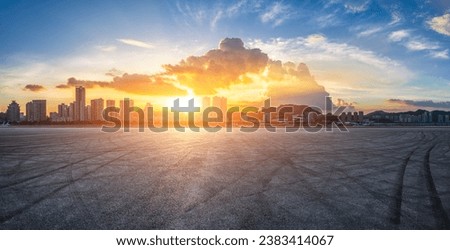 Race track road and city skyline with buildings at sunset