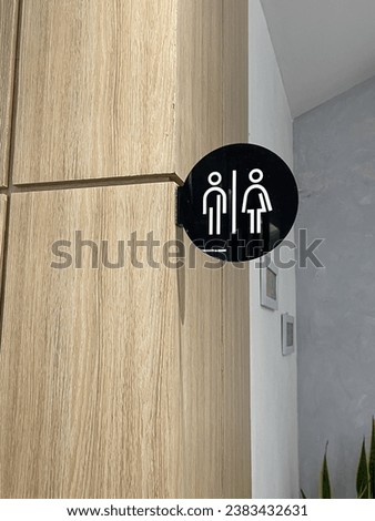 Men and Women restroom sign hanging in a public space. Toilet sign icons set. Man and woman WC signs for restroom on white wall background. Leave space to write a message. Restroom Concept