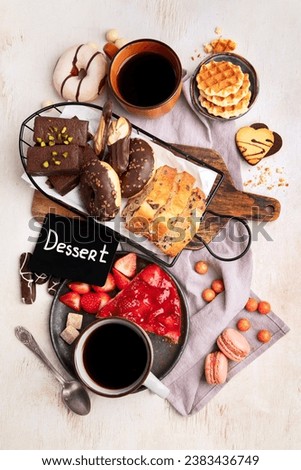 Cup of coffee with waffle, cookies, cake and dunut on light background. Hot drink and desserts. Top view.