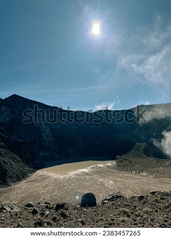 bursts of white smoke from inside the volcanic crater