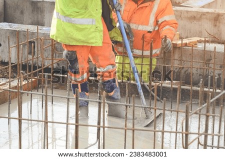 Concrete cast-in-place work. Builder level wet concrete. Concrete works on buildiiing construction site Royalty-Free Stock Photo #2383483001