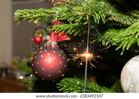 Ruggell, Liechtenstein, December 24, 2022 Burning bengal fire during christmas celebration on a fir tree