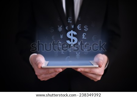 Businessman holding a tablet with a projected on-screen icon online trading dollar. business concept. Internet concept. 