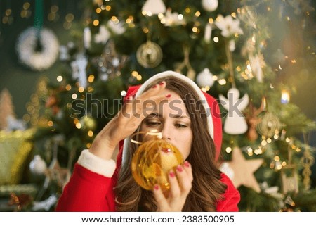 Christmas time. stylish 40 years old housewife woman witching with near Christmas tree in the modern living room. Royalty-Free Stock Photo #2383500905