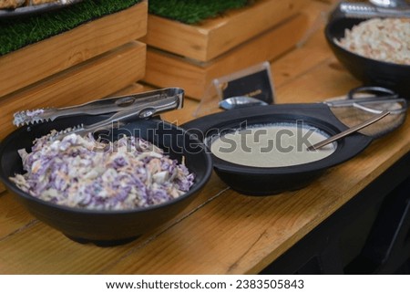 a shot coleslaw salad in the foreground with Jamaican bone broth soup in soft focus to the camera