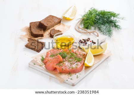 appetizer - salted salmon, bread and ingredients on a wooden board, horizontal
