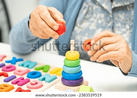 Alzheimer disease AD, Asian elderly woman patient suffering from dementia learn practical motor skills rehabilitation. Royalty-Free Stock Photo #2383539519