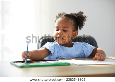 African child girl pick up color pencil and drawing on paper