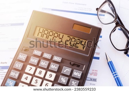 HAPPY 2024 text message on calculator display on workplace background. Concept of happy new year in business